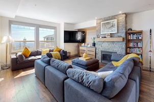 Una sala de estar moderna con un sofá modular, una chimenea, un televisor y una estantería.