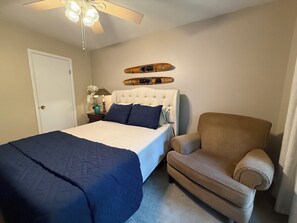A bedroom with a bed, a chair, a nightstand, a lamp, and a ceiling fan. - De Soto Golf Retreat #157 (Hot Springs)