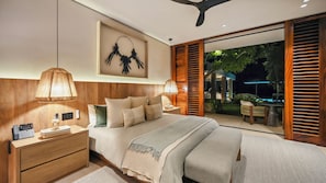 A modern bedroom with a large bed, bedside tables, a wall-mounted artwork, and a view of an outdoor garden area.