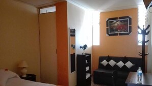 A hotel room with a bed, a sofa, a desk, and a mirror. - Qori Arequipa (Arequipa)