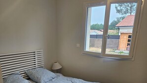A bedroom with a bed, a window, and a nightstand. - Well-equipped house with air conditioning and a spa (Saint-Avit)
