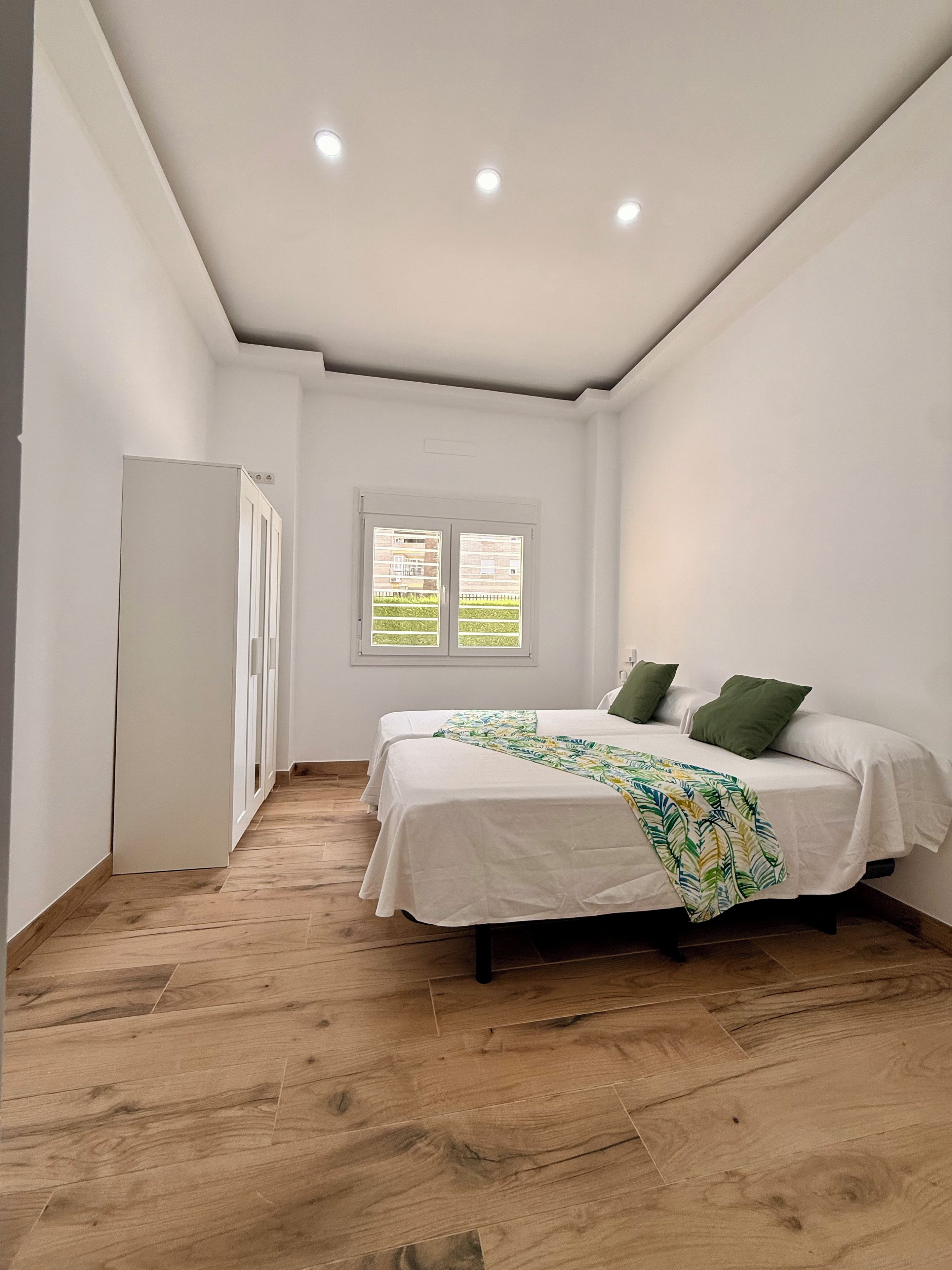 A bedroom with a bed, a window, and a door.