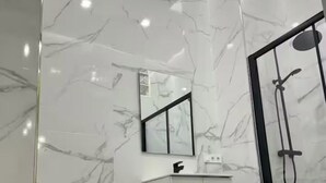 Une salle de bain moderne avec un meuble-lavabo blanc, un miroir, des toilettes et un espace douche.