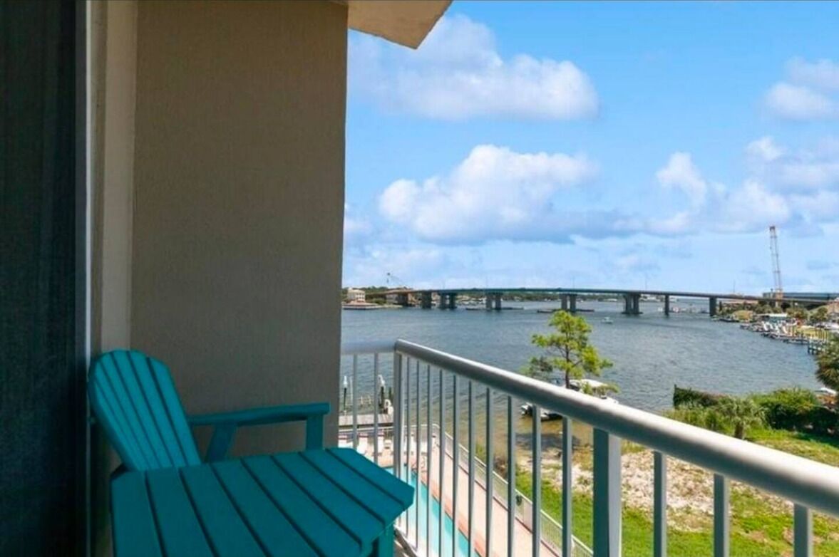 En balkon med udsigt til en flod, en bro og både.