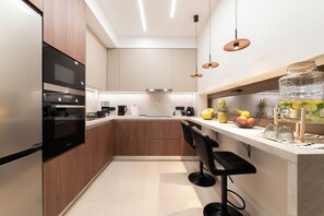 A modern kitchen with built-in appliances, a bar area, and a fruit bowl. - Villa Penelope, Heraklion, Crete, Gazi (Gazi)