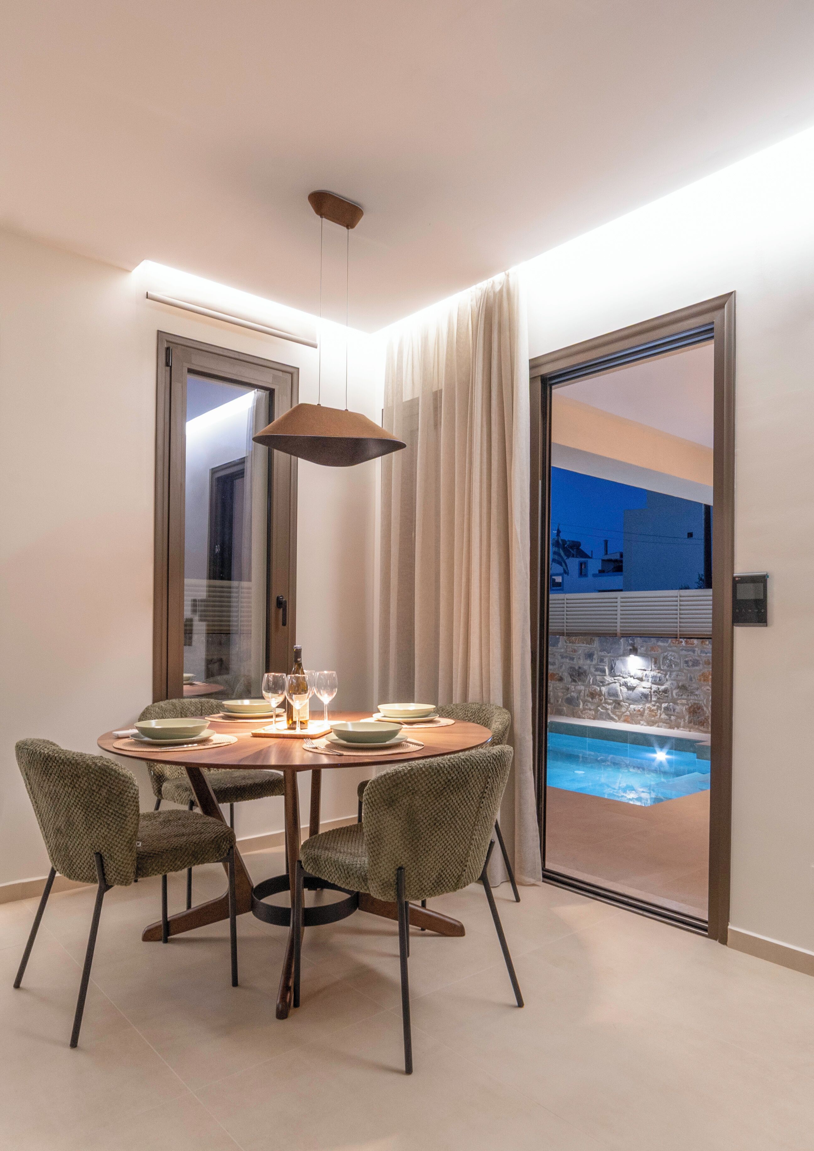 A dining area with a table, chairs, and a view of an outdoor swimming pool.