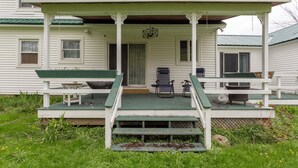 A porch with two chairs and a table, a door, and a small step leading up to the porch. - Gorgeous 5-bedroom house in welcoming Ellicottville perfect for families (Ellicottville)