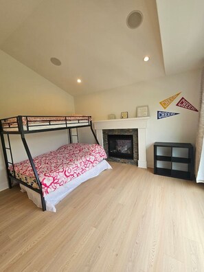 A bunk bed with a patterned bedspread, a fireplace, and wall decorations. - Luxe 4BD family retreat w/AC, Yard, Bunks and King (Calgary)