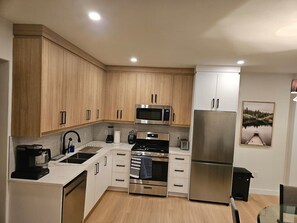 Eine moderne Küche mit Holzausstattung, Edelstahlgeräten und einem eingebauten Backofen.