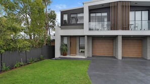 A modern two-story house with a flat roof, large windows, and a garage. - Salt & Spa Norah Head (Norah Head)