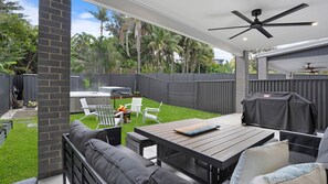 Un jardin avec un espace patio, du mobilier d’extérieur, un barbecue et un jacuzzi.