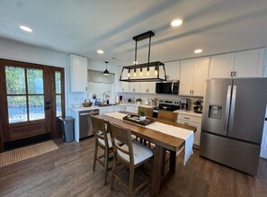 A modern kitchen with a central island, stainless steel appliances, and a large window. - Bluff View Overlooking Sequatchie Valley. 2 King Beds + Hot Tub (Graysville)