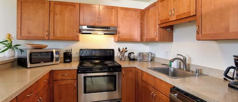 Una cocina moderna con armarios de madera, electrodomésticos de acero inoxidable y encimera de granito.