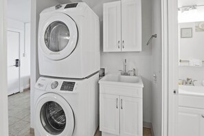 A laundry room with stacked washers and dryers, a sink, and a cabinet. - Kihei Holiday 215 (Kihei)