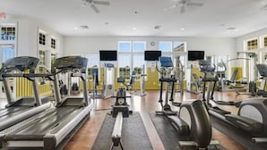 Uma academia com esteiras, elípticos e equipamentos de musculação.