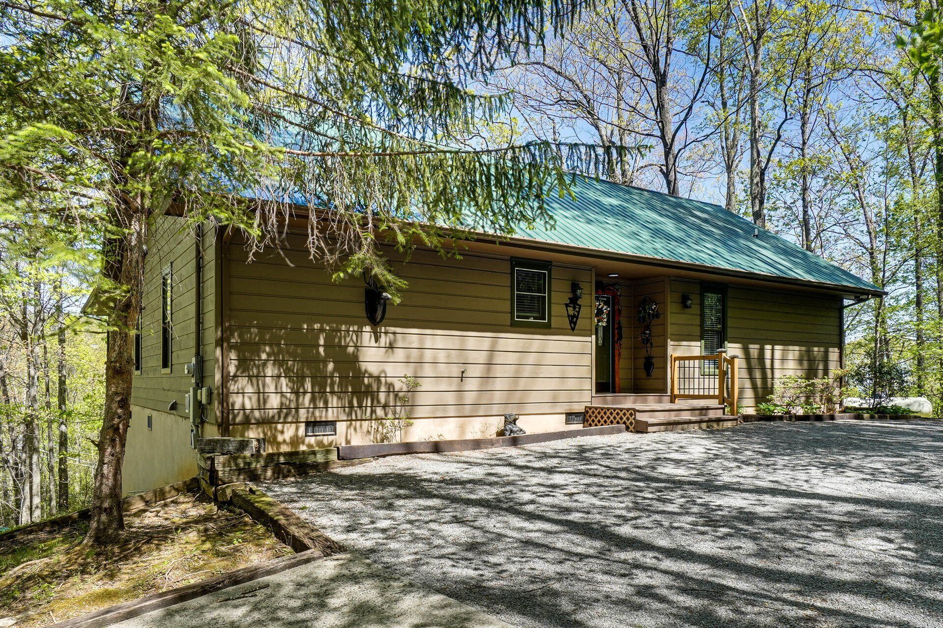 Une cabane de plain-pied avec un toit végétalisé, une véranda et une allée gravillonnée.