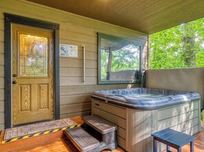 A wooden door with a glass panel, a hot tub, and a small table. - 2 King suites, pool table, hot tub, minutes to downtown Gatlinburg & nat'l park (Gatlinburg)