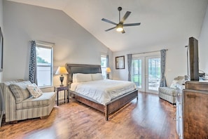 Une chambre à coucher avec un grand lit, un ventilateur de plafond, un canapé et une commode.