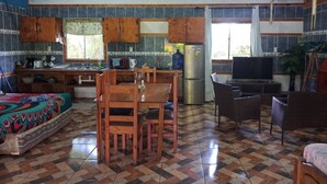 Amplia sala de estar con cocina, mesa de comedor y asientos.