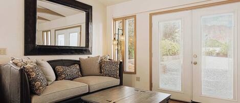 A living room with a sofa, coffee table, and a large mirror.