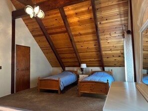 A bedroom with two wooden beds, a ceiling fan, and a window with a view. - 3-bedroom cabin in gorgeous South Lake Tahoe with AC (South Lake Tahoe)
