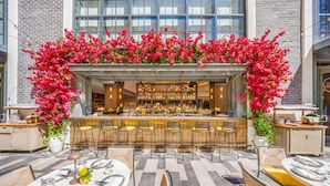 An outdoor bar area with a long counter, multiple bar stools, and a variety of bottles and glasses. - Cozy Miami Studio | Pool & Gym | City Views (Miami)