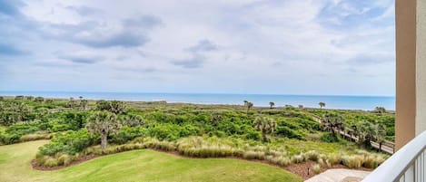 Un balcon avec vue sur un terrain de golf et l’océan.