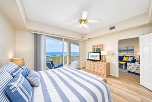 Une chambre d’hôtel avec un lit, une télévision, un bureau et une vue sur l’océan.