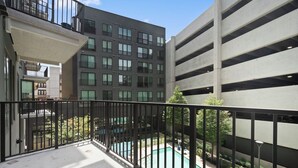 A residential building with a balcony overlooking a swimming pool. - Modern West Midtown Retreat -Balcony + Pool + Gym (Atlanta)