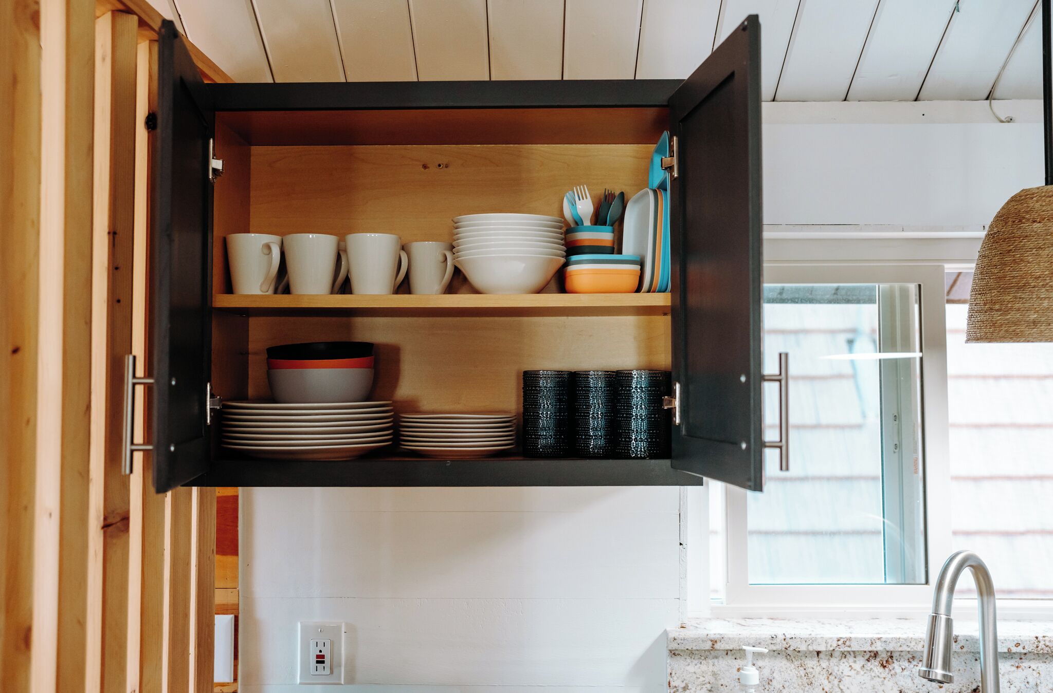 Una cocina con armarios de madera, una encimera y un ventanal.