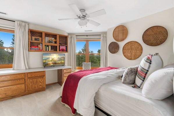 A bedroom with a bed, a desk, a television, and a view of the outdoors. - Hot Tub*A/C*Pool Table*Xbox*Fireplace (Flagstaff)
