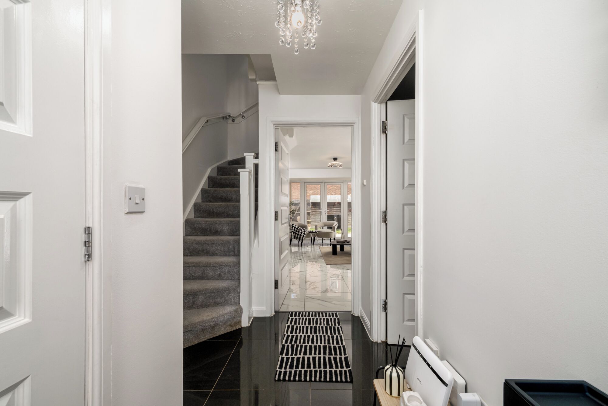 A hallway with a staircase leading to a dining area.
