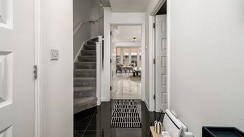 A hallway with a staircase leading to a dining area.