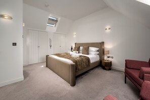 Une chambre à coucher avec un grand lit, une table de chevet, une chaise et une armoire.