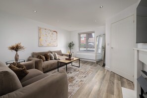 Un salon moderne avec un canapé, une table basse et un tableau accroché au mur.