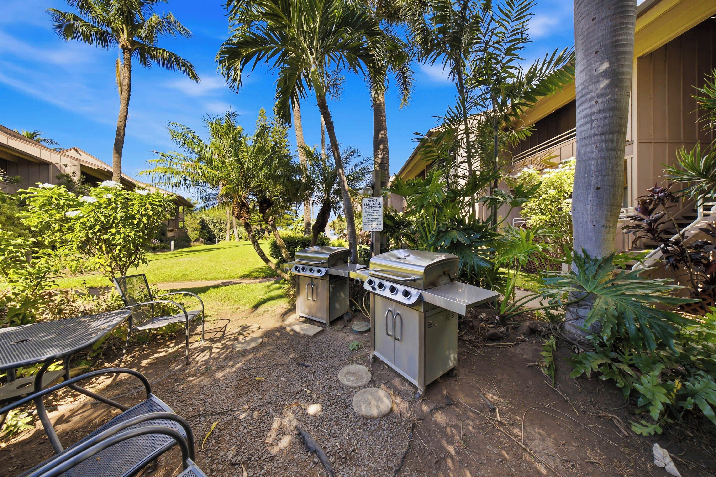 An outdoor grill area with a sign, a metal table, and chairs.