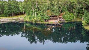 A lakeside cabin with a dock, surrounded by dense forest. - Longhorn Lakeside Chalet (Beach, Hot Tub, Kayaks) (Innsbrook)