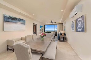 A spacious room with a long table, comfortable seating, and artwork on the walls. - CCV Quivira - Amazing 2BR Copala Condo w/ Ocean Views (Cabo San Lucas)