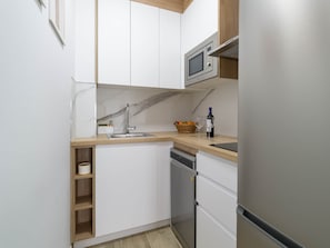 A compact kitchen with a built-in microwave, a sink, and a dishwasher. - Paraíso Canteras - Beachfront Living! (Las Palmas de Gran Canaria)