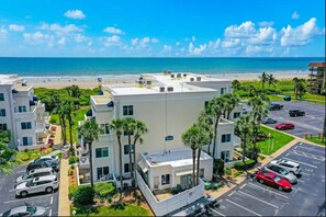 A hotel with multiple buildings, a parking lot, and a beach view. - Royal Mansions 3302 (Cape Canaveral)