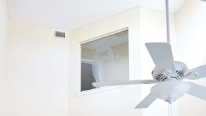 Ett kompakt bostadsutrymme med matplats, kök och en trappa som leder upp till en övre våning.