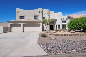 A residential property with a garage, a driveway, and a landscaped front yard with rocks and plants. - Spacious 5-bedroom house in serene Lake Havasu with pool, and Lake view (Lake Havasu City)