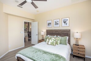 A bedroom with a bed, two nightstands, a ceiling fan, and three framed pictures on the wall. - Spacious 5-bedroom house in serene Lake Havasu with pool, and Lake view (Lake Havasu City)