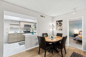 A compact living space with a kitchenette, dining area, and bedroom. - Sandpiper Towers 512 (Satellite Beach)