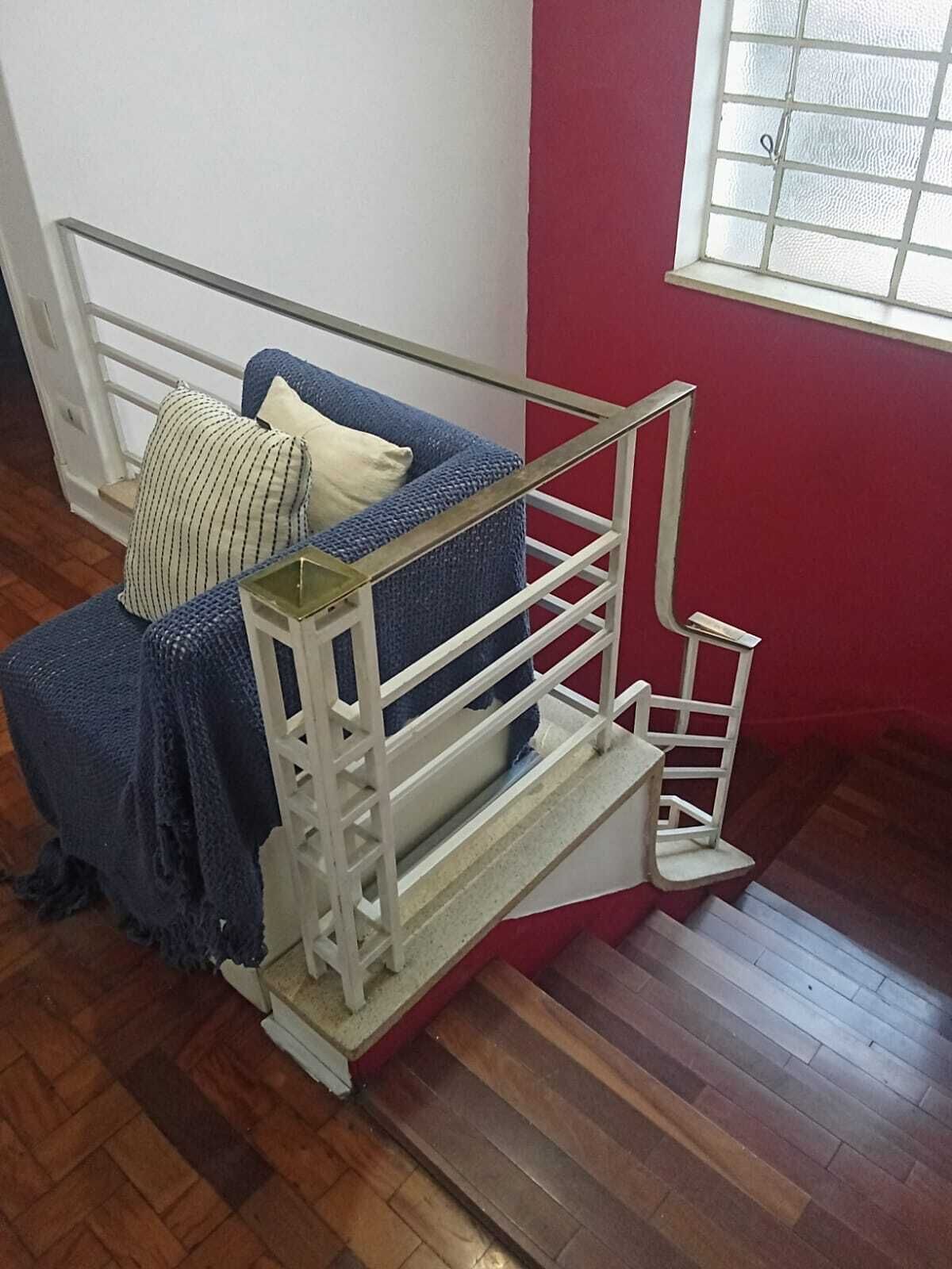 A bunk bed with a metal frame, a blue blanket, and a pillow.