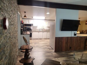 A modern kitchen with white cabinets, a built-in oven, and a microwave.