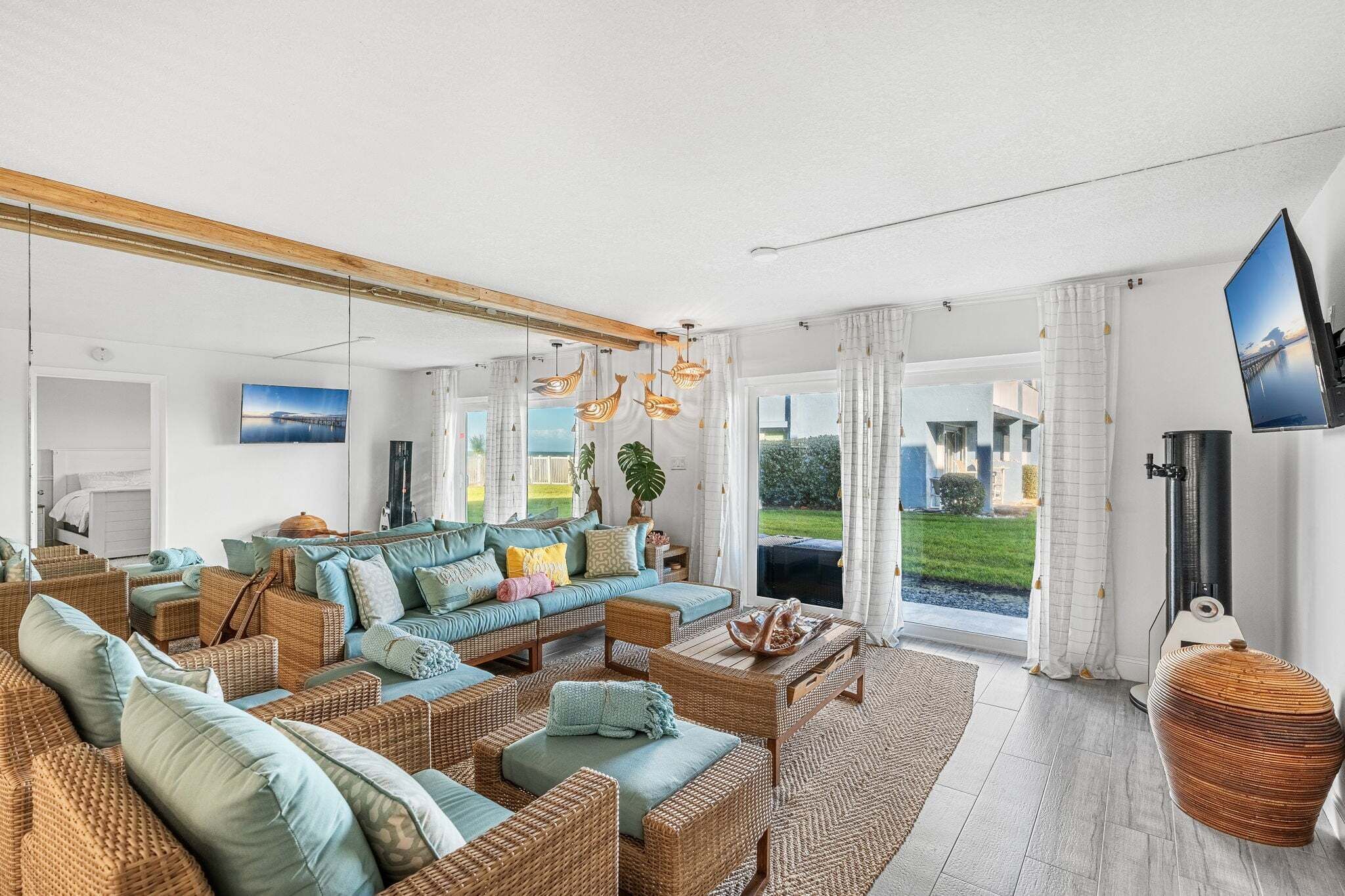 A spacious living room with a large sofa, wicker furniture, and a view of the outdoors.