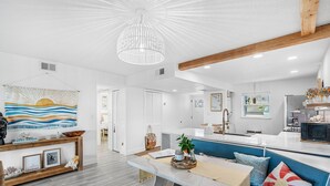 A modern living room with a dining area, a kitchen, and a bathroom. - Seabreakers 2 (Satellite Beach)