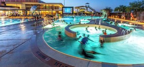 Ein großer Außenpoolbereich mit mehreren Wasserspielen und einer überdachten Sitzgelegenheit.