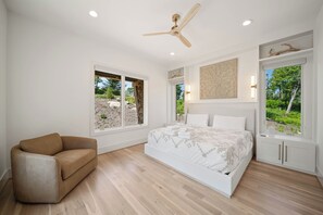 A bedroom with a bed, a sofa, a ceiling fan, and large windows. - High View: Brand-New 5,100 Sq Ft Nordic-Inspired Mountain Estate with Four-State Views (Banner Elk)